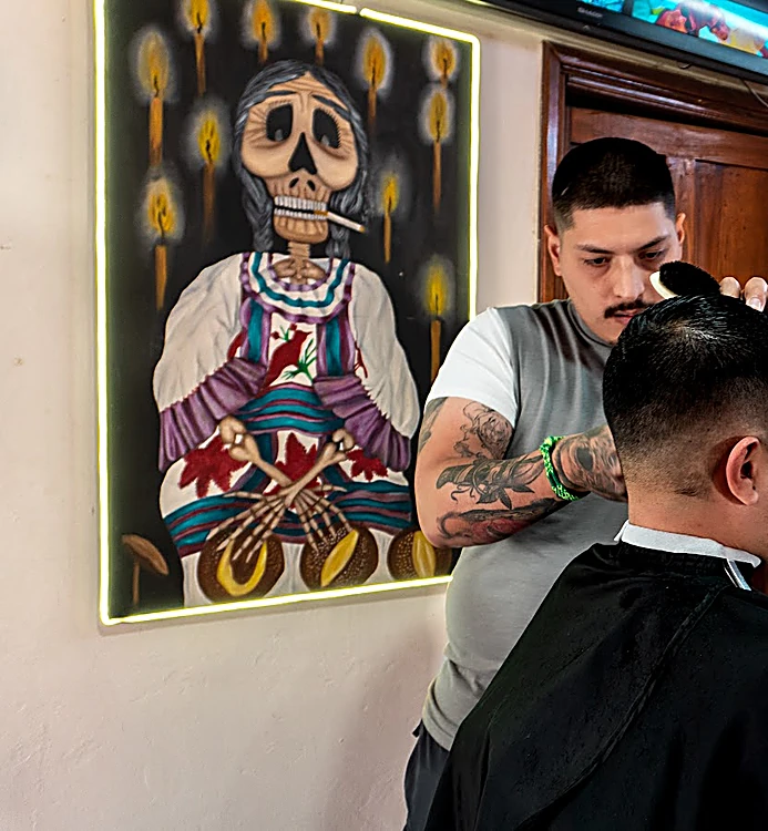 Cuadro al óleo de una Catrina con velas, colgado junto a la estación de corte